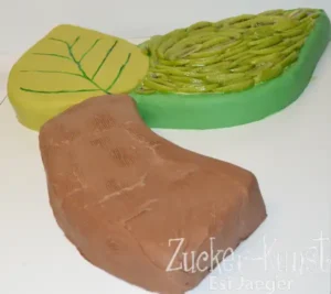 Themen-Hochzeitstorte: Blattform mit Kiwischeiben und Holzstamm-Form, grüne und braune Fondant-Deko. Einzigartiges Design. Zucker-Kunst Esi Jaeger.