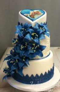 Drreistöckige Hochzeitstorte mit essbaren blauen Zuckerlilien verziert.
