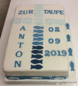 Rechteckige weiße Tauftorte mit blauen Fische-Symbolen in verschiedenen Schattierungen und dem Datum der Taufe.