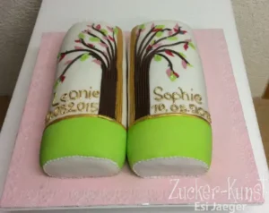 Zweiteilige Tauftorte für Zwillinge mit einem durchgehenden Baum-Motiv, das beide Seiten vereint, in Weiß, Grün und Pink.