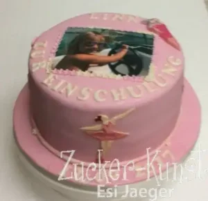 Runde Einschulungstorte in Pink mit einem persönlichen Foto-Druck, der Aufschrift "Zur Einschulung" und Ballerina-Motiv.