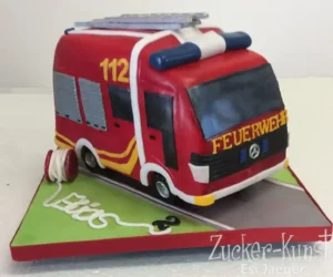 Modellierte Geburtstagstorte in Form eines roten Feuerwehrautos mit der Nummer 112 und ausgerolltem Schlauch.