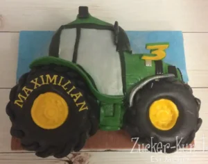 Modellierte Geburtstagstorte in Form eines großen, grünen Traktors mit der Zahl Drei.