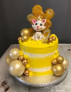 Zweistöckige gelbe Katze-Prinzessin Torte zum 2. Geburtstag mit Milchmädchen-Füllung und hohlen Schokoladen-Kugeln.