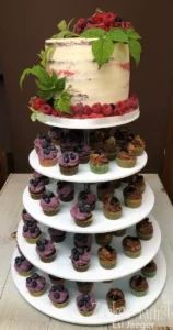 Kombi-Hochzeitstorte: Naked Cake mit frischen Beeren und Beerenblättern, umgeben von Schokoladen- und Beeren-Cupcakes auf 5-stöckiger Etagere.