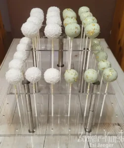 Zwei Sorten eleganter Cake Pops: weiße Kokos-Cake Pops und mintgrüne Cake Pops mit essbaren Goldflocken