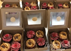 Cupcakes Stuttgart: Sortierte Cupcakes in Geschenkboxen mit Himbeeren und Salzbrezeln.