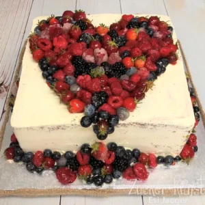 Geburtstagstorte Frau: Eckige Beeren-Torte mit herzförmiger Frucht-Deko.