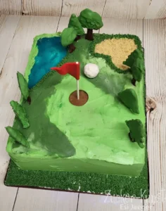 Ausgefallene Geburtstagstorte für Männer: Torte im Golfplatz-Design mit Flagge und Ball.
